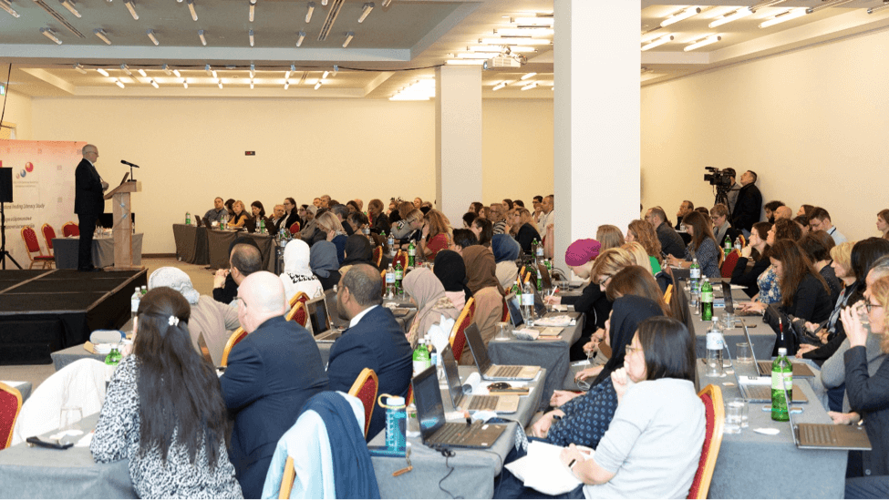 participants in large meeting, with videographers